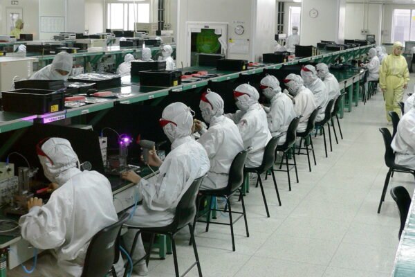 Workers in protective suits on an electronics factory floor in Shenzhen.