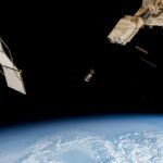 A trio of CubeSats in Earth orbit, seen against the blackness of space.