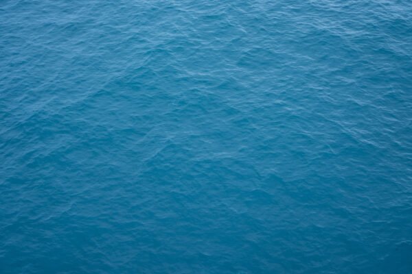An aerial view of the deep blue surface of the open ocean.
