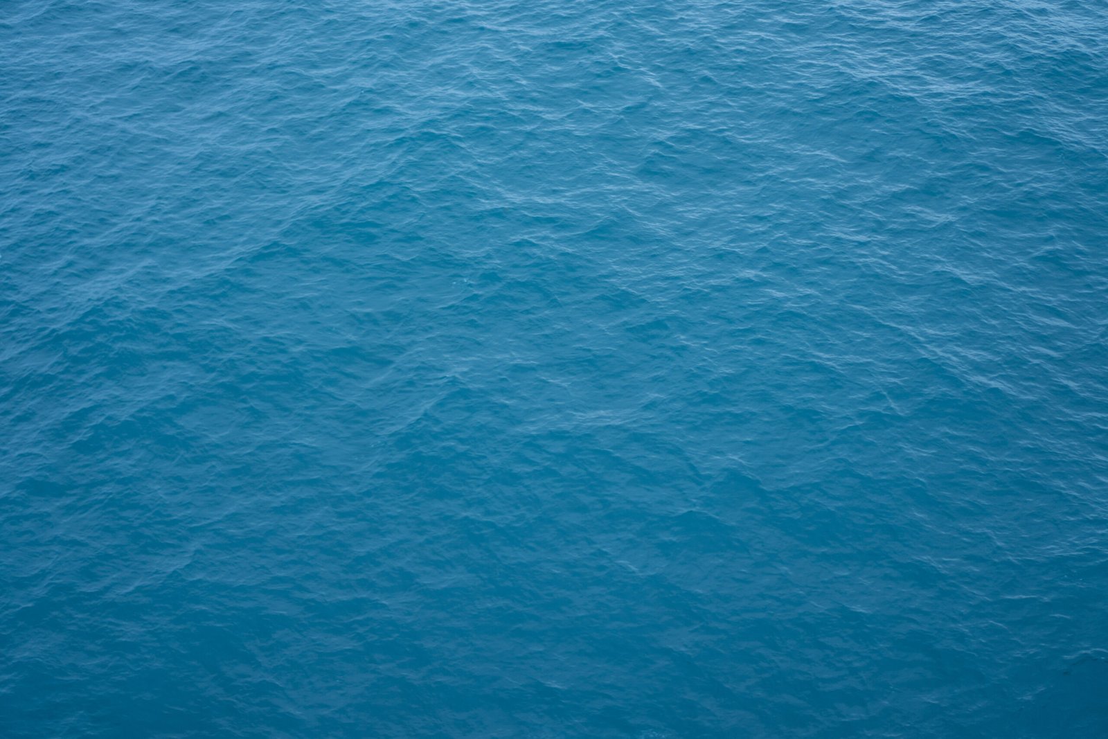 An aerial view of the deep blue surface of the open ocean.